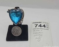 Front view showing blue heart glass stone and accent stones