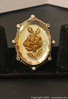 Front view of ring showing cabochon and pearl-set border