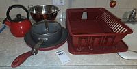 Full lot showing kettle, frying pan, saucepan with lid, colander, dish rack on countertop