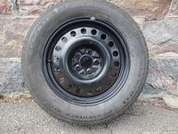 Front view of full-size spare tire mounted on black steel rim