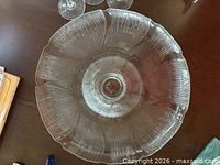 Top view of clear pressed glass cake stand showing ribbed petal pattern