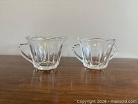 Front view of creamer and sugar bowl showing scalloped rims and ribbed panels