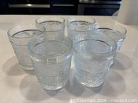 all six clear pressed glass tumblers grouped