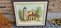 Front view of framed oil painting showing church scene, mat and frame