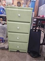 Front view of green 4-drawer dresser with white knobs