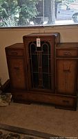 Front view of Art Deco sideboard showing central display opening, side cabinets, drawers, hardware