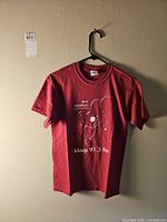 Full view of red KKUP Jazz Marathon T-shirt front on hanger