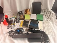 Overview of lot showing keyboard, mouse, notebooks, memo pads, stapler, cable straps, cords, decor items