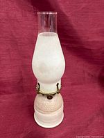 Full view of hurricane lamp showing ceramic base, frosted globe, clear chimney