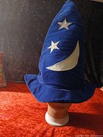 Front view of blue Mickey Sorcerer pointed hat with crescent moon and stars on mannequin head