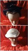 Black velvet cocktail hat with maroon feather on mannequin head