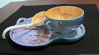 Tray, cup and ladle assembled on black background