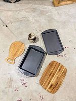 Lot overview showing two Wilton pans, two bamboo boards, ceramic vase