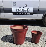 Large and small matching red glazed ceramic pots front view
