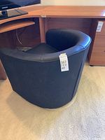 Rear and side view of black faux leather swivel chair showing upholstery and shape