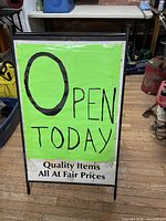 Front view of black metal A-frame sign with green "Open Today" panel inserted