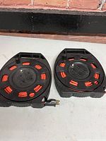 Two retractable extension cord reels showing outlets, handles and red reels