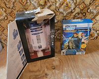 R2-D2 in damaged original box beside sealed Yoda topper box