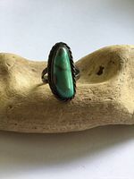 Front view of sterling silver turquoise ring on wood display