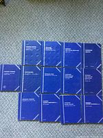 Group shot of all twelve blue Whitman folders aligned on carpet