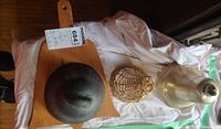 Top view showing all four items: brass bell, iron bell, wire bell, wooden cutting board