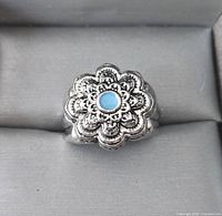 Top view of silver-plated floral ring with turquoise cabochon
