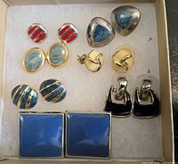 All seven pairs of earrings arranged in box lid showing colors, shapes, materials
