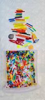 Colourful translucent LEGO pieces spread out; container visible