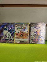 Group view of Vespiquen ex, Palossand ex and Absol ex cards in sleeves