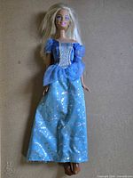 Front view of blonde Mattel doll in blue glitter gown and brown shoes