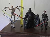 Front view of all three Star Wars action figures with tape measure for scale
