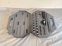 Open gray case displaying sockets, bits, driver