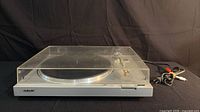 Full view of turntable with dust cover closed, cables visible