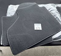 Set of four grey carpet mats stacked