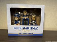 Front view of boxed Buck Martinez Legacy bobblehead showing three figures