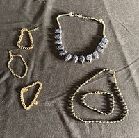 All five jewelry pieces laid out on fabric