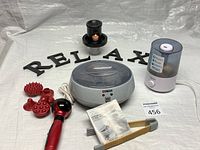 Overview of lot showing Conair hot stone unit, massager with heads, oil burner, humidifier, RELAX letters and manual