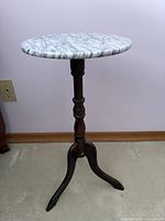 Full view of pedestal side table showing marble top and wooden base