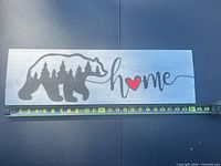 Full view of cedar wall sign with measuring tape showing length about 24 in