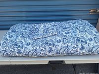 Folded queen duvet with cover and pillowcase displayed on table