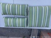Three green striped outdoor pillows displayed flat