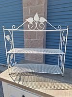 Front view of two-tier white metal wire shelf showing overall design and dimensions