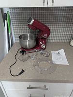 Mixer with bowl and accessories displayed on countertop