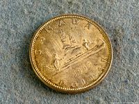 Reverse of 1965 Canadian silver dollar showing Voyageur canoe and date