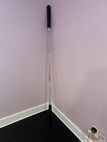 Full view of barbell leaning against wall