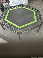 Full view of hexagonal rebounder showing frame, mat and legs