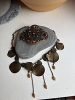Belt buckle and necklace displayed together for scale and overview