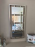 Front view showing four beveled mirror panels in silver frame