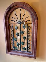 Front view showing entire arched wood frame and metal insert with leaves and turtle