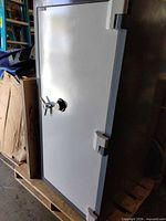 Full view of Adesco tall steel safe on pallet, showing door, frame, handle and dial